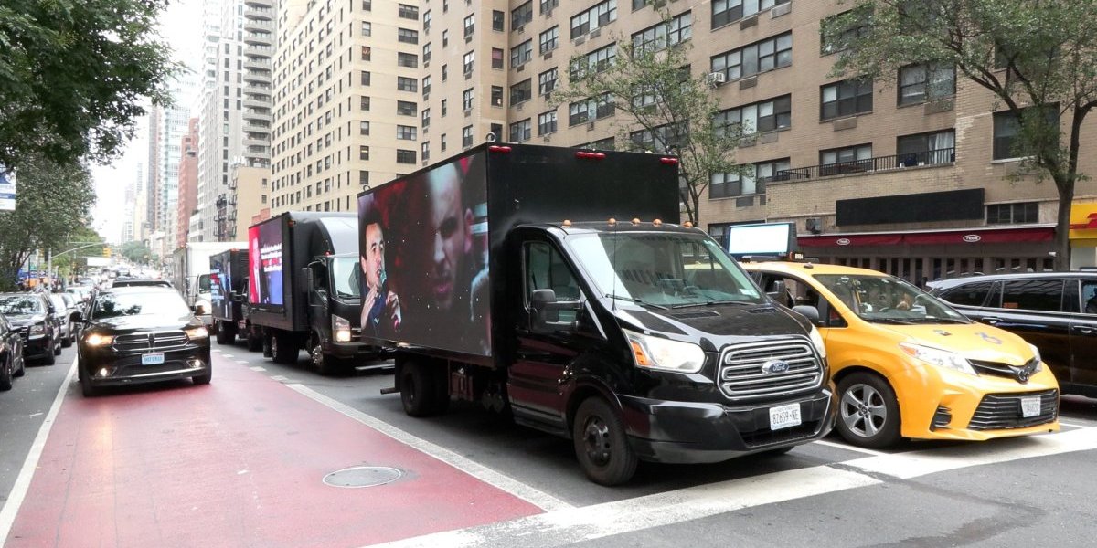 Na ulicama Njuorka idu kamioni sa bilboridma o teškom životu Srba na Kosmetu.